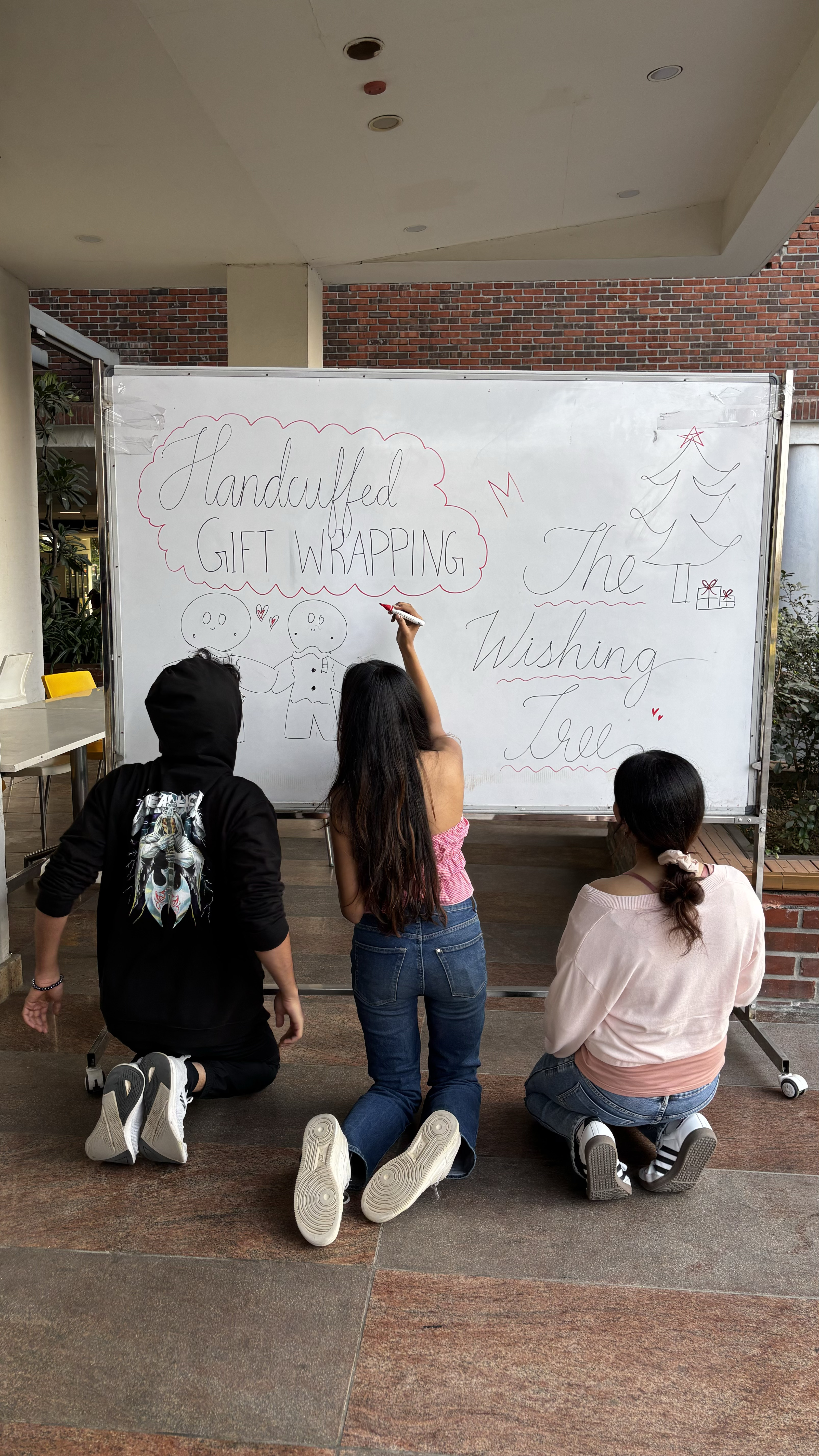 Students decorating the white board for the stall